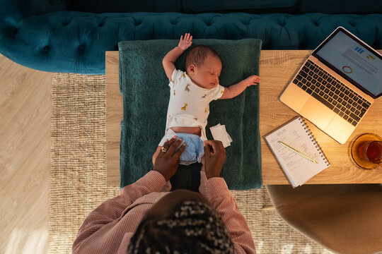 Mom changing diaper of sleeping newborn
