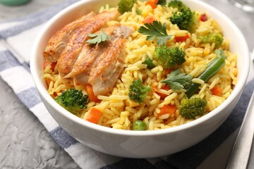 Tasty rice with vegetables and chicken on grey table, closeup