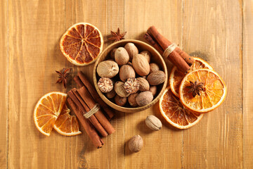 Different spices and dried orange slices on wooden table, flat lay. Christmas season