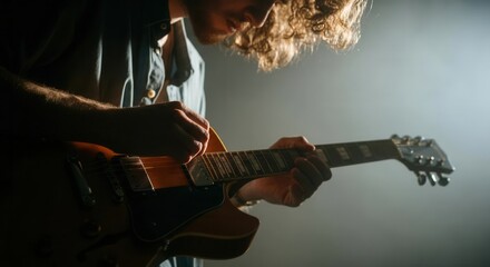 Electric guitar performance in moody stage lighting
