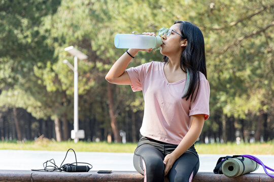 Athlete hydrates during a break from her outdoor exercise routine