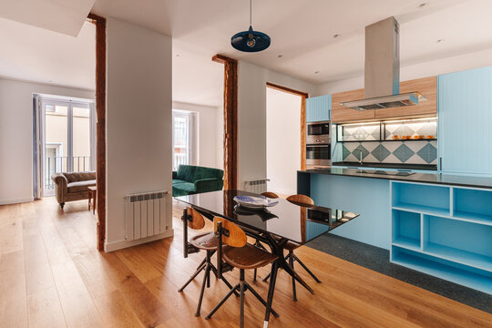 A modern open-plan kitchen and dining area with a blue kitchen island