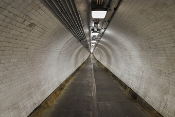 Long Underground Tunnel with Illuminated White Tiled Walls
