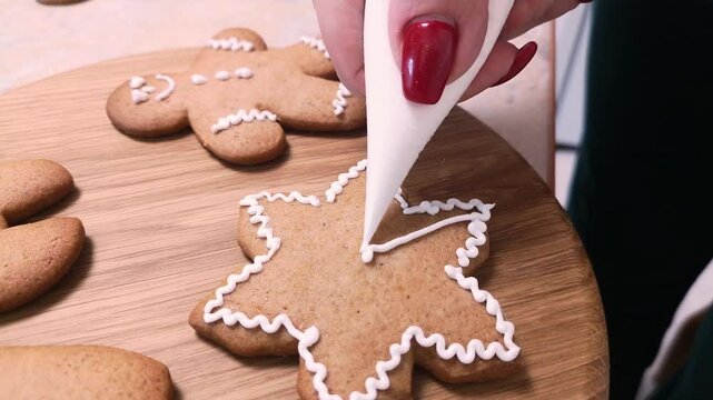 Christmas gingerbread. Handmade cookie decorating. Decorating gingerbread cookies for Christmas. Family Christmas and New Year traditions. Close-up.
