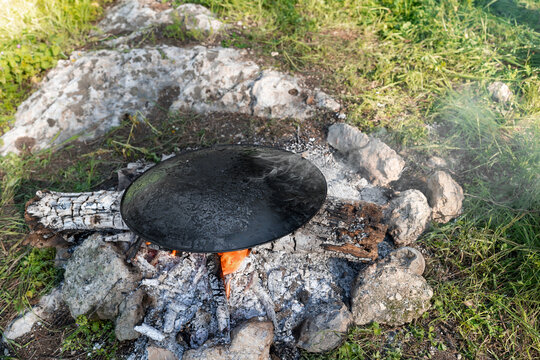 Outdoor Fire with Cooking Plate in Rustic Camp Setting.