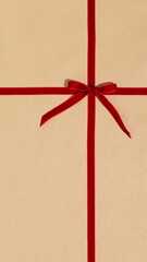 Red gift ribbon and bow on craft wrapping paper