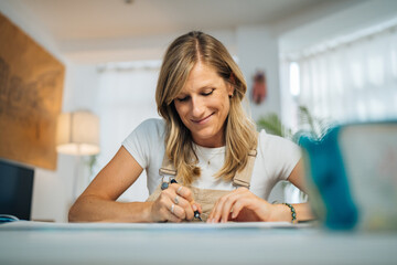 Female artist cutting paper working on geometric art at home