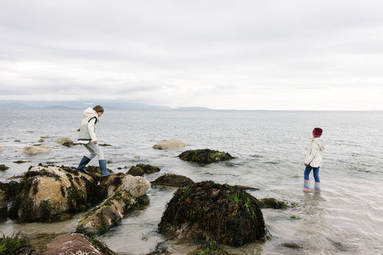 Two sisters on the beach on a cloudy day