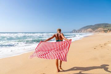 Walking on beach with striped towel