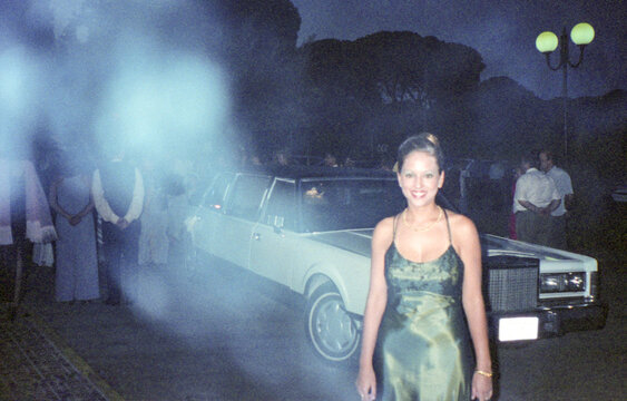 analog image of woman in an elegant dress next to a limousine