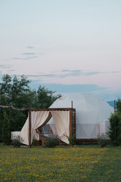 Cozy glamping dome surrounded by nature at dusk in spring season