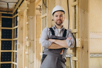 Construction worker smiling with arms crossed in modular building