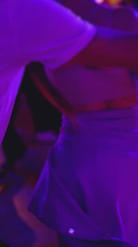 Couples dancing traditional latin argentinian dance milonga in the ballroom, tango salsa bachata kizomba lesson in red and purple lights, evening dance school class festival, performance rehearsal
