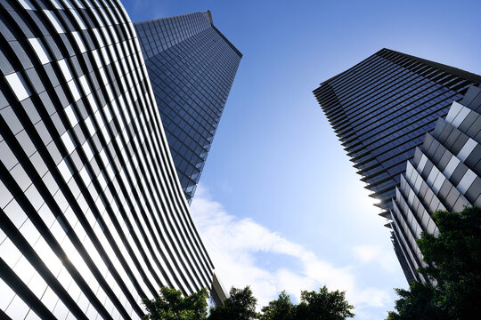 Modern skyscrapers with wavy designs against a clear blue sky