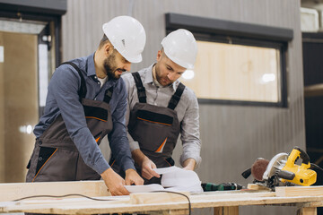 Construction workers examining blueprints for modular building project