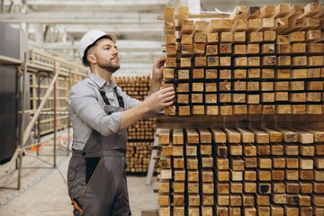 Carpenter inspecting wooden planks for modular building construction