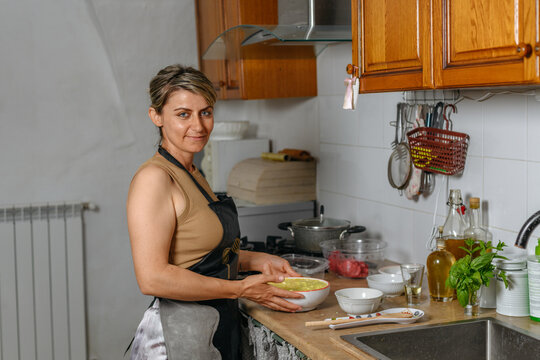 Smiling albanian woman holding a bowl with stuffing for byrek