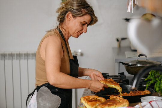 Woman serving albanian byrek filled with cheese and zucchini
