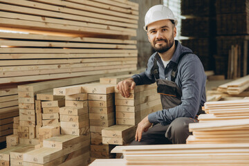 Carpenter inspecting lumber for modular building construction