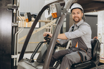 Warehouse worker driving forklift in modular building industry