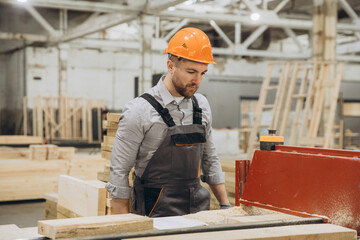 Carpenter working with wood in factory for modular building