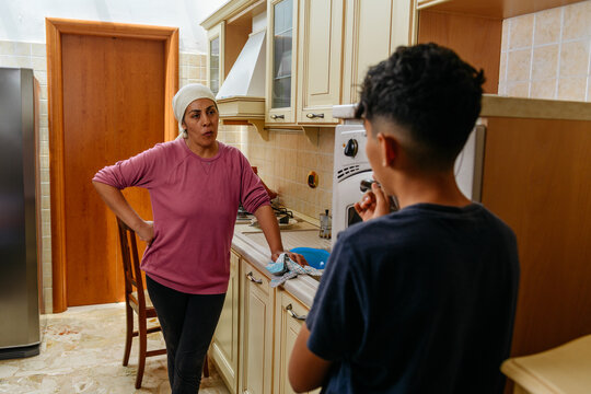 Moroccan mother scolds her son in the kitchen