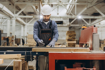 Carpenter measuring wooden plank in workshop for modular building