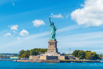 Fototapeta premium World famous Statue of Liberty under a blue sky with clouds