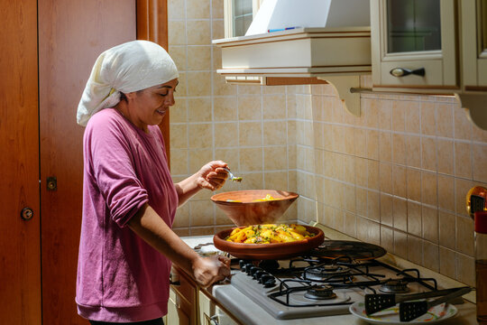 Moroccan woman tastes the traditional dish Tajine