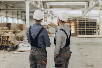 Engineers inspecting prefabricated building components in factory