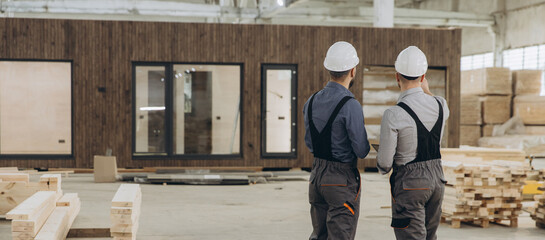 Engineers inspecting completed modular building in factory