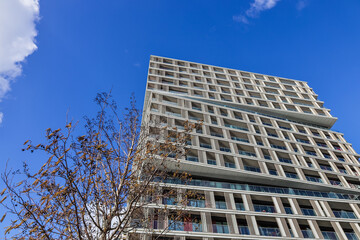 Modern High-Rise Residential Building with Glass Balconies and a Clear Blue Sky