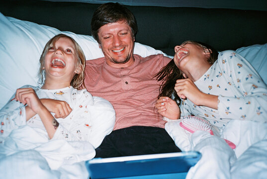 Father with daughters watching video and laughing