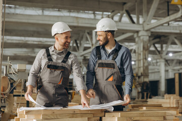 Engineers analyzing blueprints in modular building factory