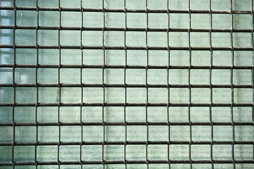 Rectangular metal link shutter in front of a shop window