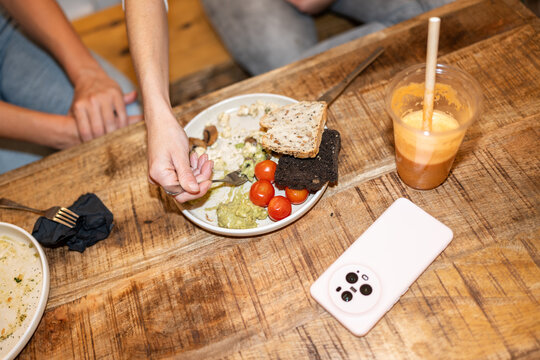 Woman finishing eating healthy vegan breakfast with friends