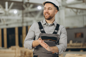 Construction worker clapping hands in modular building factory