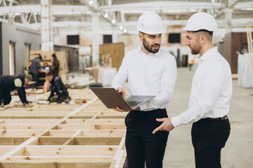 Engineers discussing modular construction in factory