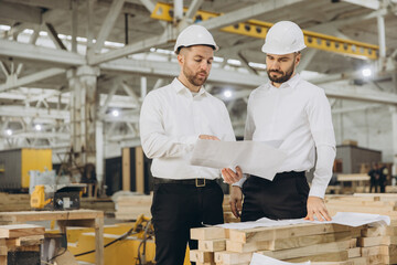 Engineers discussing plans in modular building factory