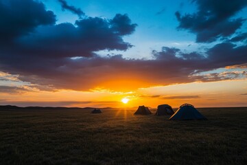 This breathtaking image captures the essence of sunset camping with tents silhouetted against a picturesque sky, representing peace and adventure in the great outdoors.