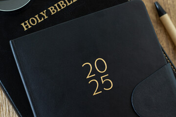 2025 calendar notebook with holy bible book. Close-up. Top view. Christian education, learning,...