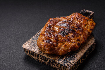 Juicy pork steak baked on the grill with salt, spices and herbs