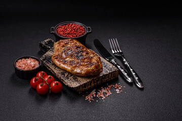 Juicy pork steak baked on the grill with salt, spices and herbs