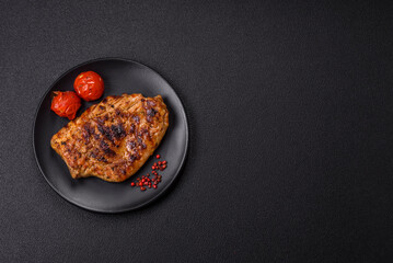 Juicy pork steak baked on the grill with salt, spices and herbs