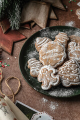 Christmas gingerbread cookies close up in plate on rustic table with fir branches, spices, christmas decorations. Merry Christmas, atmospheric holiday