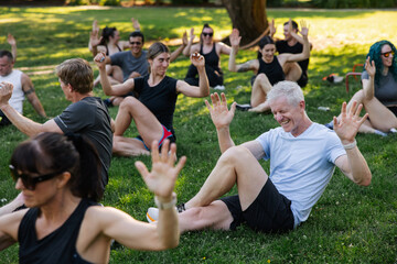 Laughing man in Group of People Exercising Outdoors in Summer Pa
