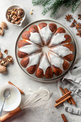 Christmas gingerbread cake glazed on white table with fir branches and spices. Christmas festive dessert, homemade holiday baking recipe. Top view