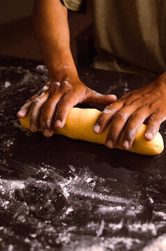Male hands of a pastry chef, preparing dough in an artisanal way in his workshop, step by step. Food concept.