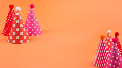 Obraz premium Colorful birthday caps on orange background.