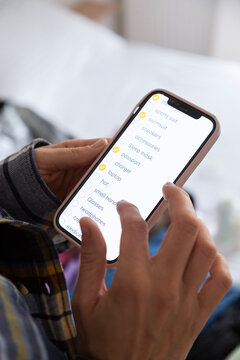 Person checking items packing list using checklist app on smartphon